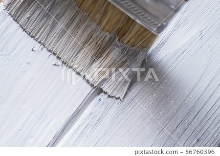 The process of painting paintbrush wooden surface of old(rustic) brown wood planks on white color. burned planks of pine tree. Close up The process of painting paintbrush wooden surface of old(rustic) brown wood planks on white color. burned planks of pine tree. Close up 86760396