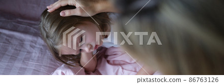 Mom puts sad girl on head before going to bed. 86763126