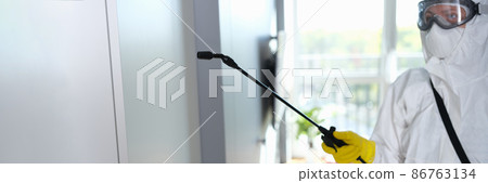Employee in protective suit, mask and goggles disinfects premises closrup Employee in protective suit, mask and goggles disinfects premises closrup 86763134