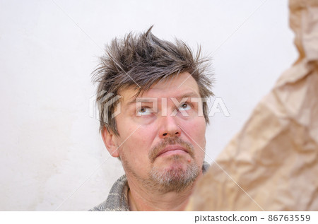 A grown man rolls his eyes and looks up at the ceiling. 86763559