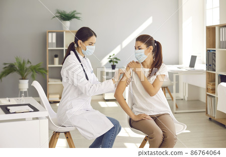 Female doctor or nurse vaccinate young woman patient in clinic. Woman GP make injection give vaccination against covid-19 corona virus to girl client in hospital. Coronavirus, healthcare, medicine. Female doctor or nurse vaccinate young woman patient in clinic. Woman GP make injection give vaccination against covid-19 corona virus to girl client in hospital. Coronavirus, healthcare, medicine. 86764064