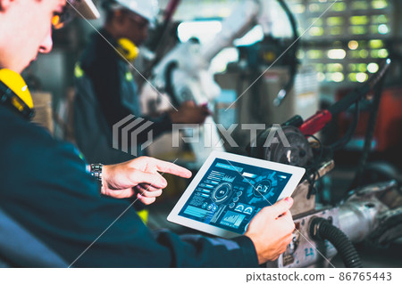 Factory workers working with adept robotic arm in a workshop 86765443