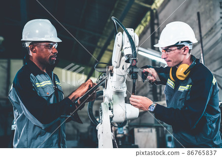 Factory workers working with adept robotic arm in a workshop 86765837