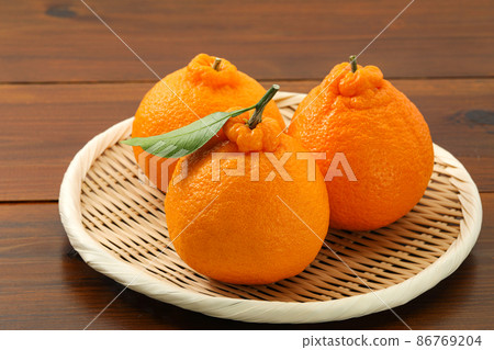 Dekopon with leaves on a colander Dekopon with leaves on a colander 86769204