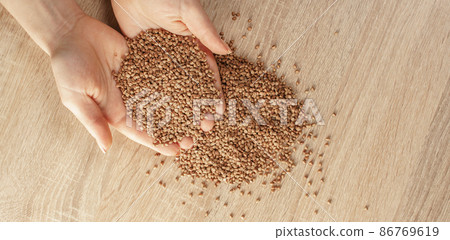 raw buckwheat in hands 86769619