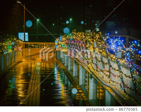 Illuminated pedestrian bridge on a snowy night 86770365
