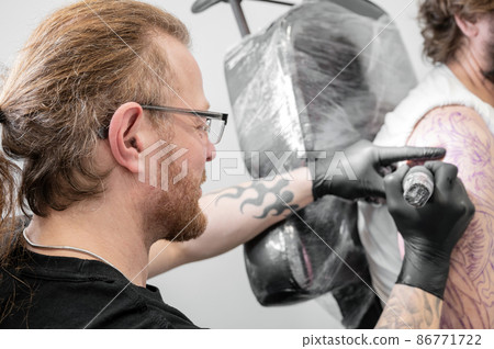 Salon tattoo. Close up of a Tattoo artist working. Tattoo artist make tattoo at the studio. 86771722