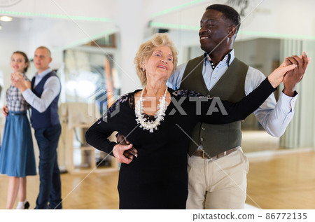 Man and mature woman learning to dance classical ballroom dance Man and mature woman learning to dance classical ballroom dance 86772135