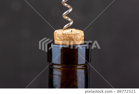 Closeup of a corkscrew inside a wine cork in a bottle. Closeup of a corkscrew inside a wine cork in a bottle. 86772521