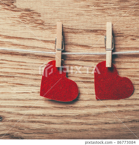 two red hearts on clothespins on wooden background 86773084