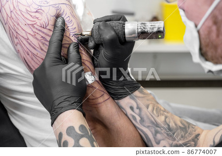 Salon tattoo. Close up of a Tattoo artist working. Tattoo artist make tattoo at the studio. 86774007