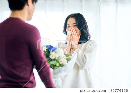 A man handing a bouquet on an anniversary 86774166