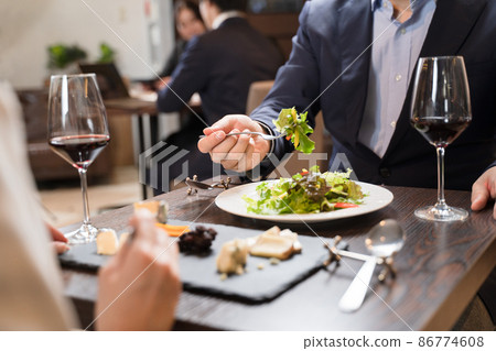 Men and women eating while having a conversation at a restaurant Men and women eating while having a conversation at a restaurant 86774608