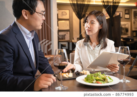 諮詢餐館菜單的婦女 諮詢餐館菜單的婦女 86774993