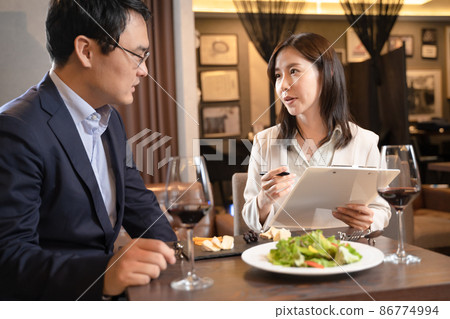 諮詢餐館菜單的婦女 諮詢餐館菜單的婦女 86774994