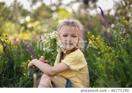 Girl with a bouquet of daisies sits in the forest Girl with a bouquet of daisies sits in the forest 86775190