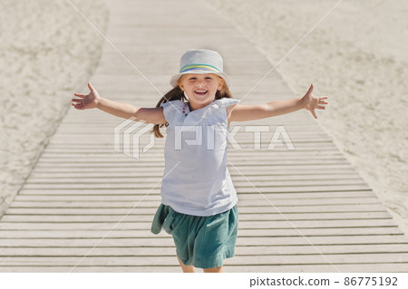Little girl running on the beach of ocean Little girl running on the beach of ocean 86775192