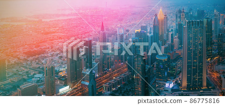 Aerial View Of Evening Night Scenic View Of Skyscraper. Street Night Illumination. Waterfront And Dubai Cityscape In Summer Evening. Night Scenic View Of Dubai Skyline. Film effect, lens flare, glow Aerial View Of Evening Night Scenic View Of Skyscraper. Street Night Illumination. Waterfront And Dubai Cityscape In Summer Evening. Night Scenic View Of Dubai Skyline. Film effect, lens flare, glow 86775816