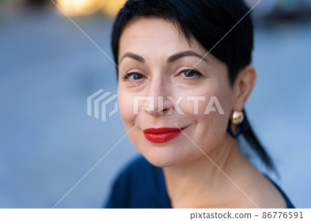 An elegant woman in a stylish outfit poses on a city street An elegant woman in a stylish outfit poses on a city street 86776591
