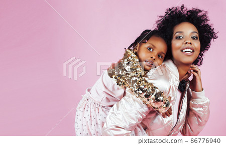 young pretty african-american mother with little cute daughter hugging, happy smiling on pink background, lifestyle modern people concept young pretty african-american mother with little cute daughter hugging, happy smiling on pink background, lifestyle modern people concept 86776940