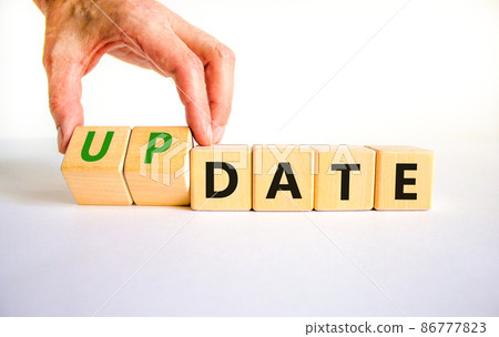 Date or update symbol. Businessman turns wooden cubes and changes the concept word date to update. Beautiful white table, white background, copy space. Business and date or update concept. 86777823