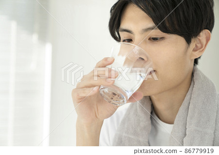 A young man drinking water A young man drinking water 86779919
