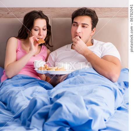 Happy family having breakfast in bed 86782041