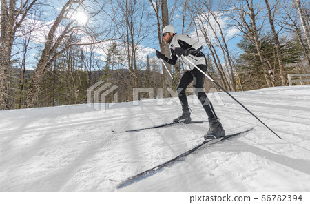 Winter sport. Man Cross Country Skate Skiing Style - Nordic Ski in Forest. Man in winter doing fun endurance winter sport activity in the snow on cross country ski in beautiful nature landscape 86782394