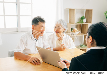 一個穿西裝的女人和一對老夫婦在電腦上解釋 86783084