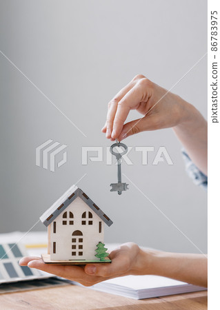 a beautiful small model of a house in women's hands 86783975