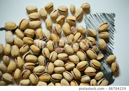 Top view of Pistachio nuts in wooden bowl on checkered cloth. High quality photo Top view of Pistachio nuts in wooden bowl on checkered cloth. High quality photo 86784229
