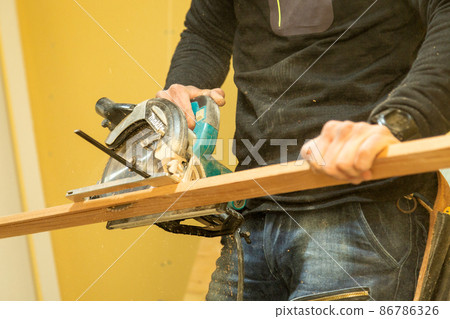 Carpenter doing new detached house construction work 86786326