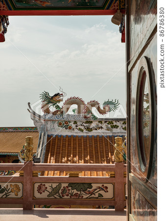 Roof architecture of Chinese style temple and Chinese dragon sculpture. 86786380
