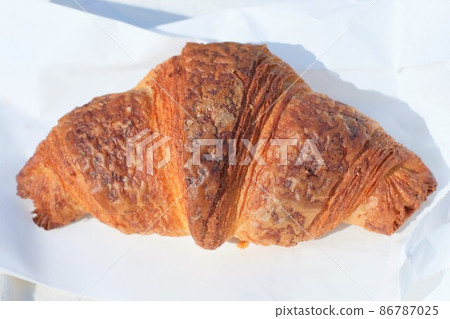 Croissant placed on a white paper bag 86787025