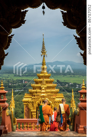Buddhist Monks are walking into down the gate of Wat Phra That Doi Phra Chan in Lampang. 86787052