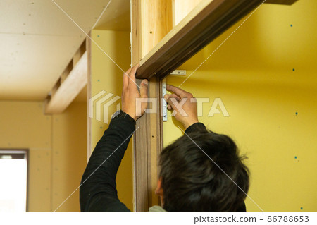 Carpenter doing new detached house construction work 86788653