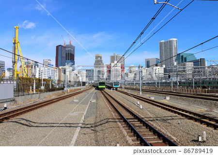 山手線E235系列列車和京濱東北線E233系列臥舖特快“日出瀨戶/出雲”在高輪門戶站 86789419