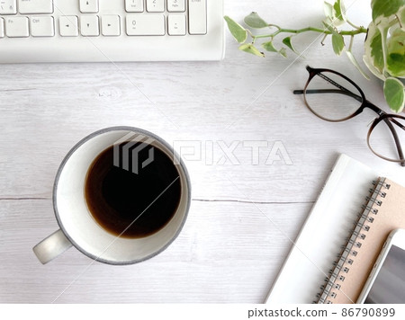 A mug of coffee and small items on the desk 86790899