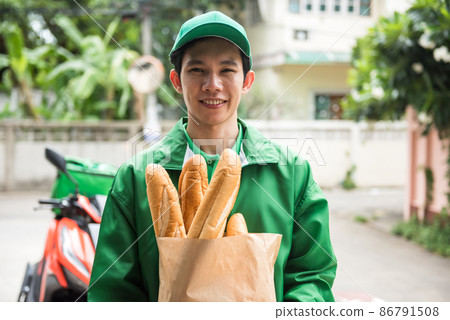 deliveryman hold bread to deliver by motorbike 86791508