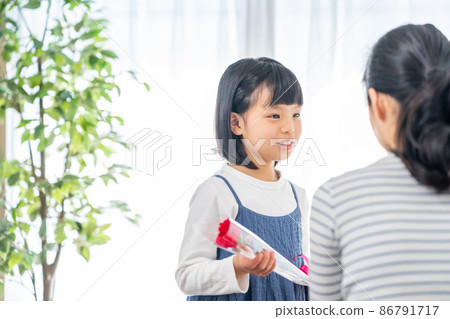 Girl giving carnations to her mother on Mother's Day Girl giving carnations to her mother on Mother's Day 86791717