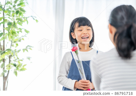Girl giving carnations to her mother on Mother's Day Girl giving carnations to her mother on Mother's Day 86791718