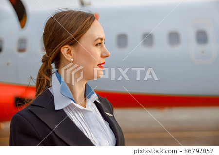 Female flight attendant standing outdoors at airfield 86792052
