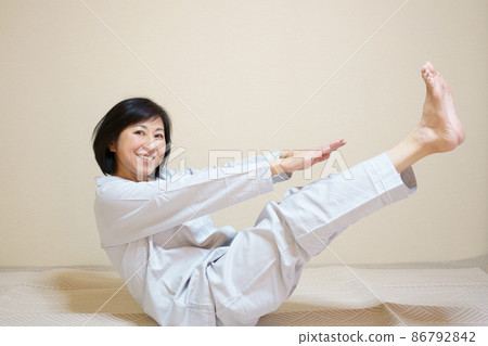 Middle-aged female exercising before going to bed looking at the camera Middle-aged female exercising before going to bed looking at the camera 86792842