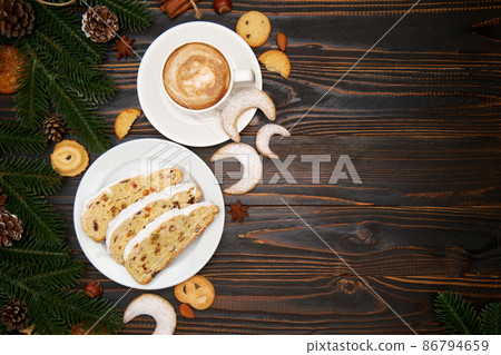 Sliced Traditional Christmas stollen cake with marzipan and dried fruit with New Year decorations 86794659