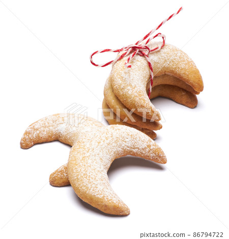 Rope tied pile of traditional Vanillekipferl vanilla kipferl cookies isolated on white background Rope tied pile of traditional Vanillekipferl vanilla kipferl cookies isolated on white background 86794722