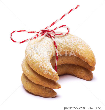 Rope tied pile of traditional Vanillekipferl vanilla kipferl cookies isolated on white background Rope tied pile of traditional Vanillekipferl vanilla kipferl cookies isolated on white background 86794723