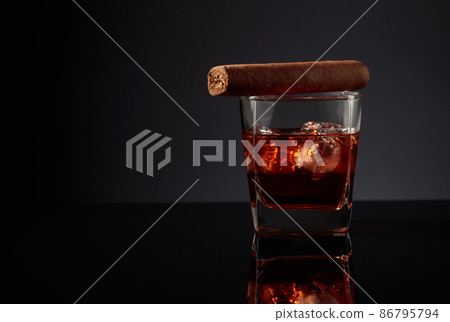 Glass of whiskey with ice and cigar. 86795794
