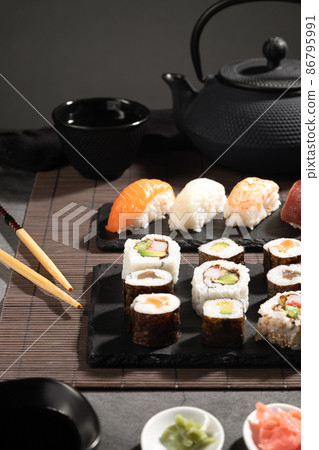 Closeup of fresh  variety sushi on dark background. Sushi set and japanese tea. Vertical format. 86795991
