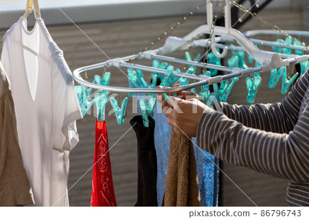 一個女人在陽台上曬衣服 86796743