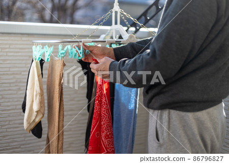 一個男人在陽台上曬衣服 一個男人在陽台上曬衣服 86796827